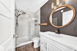 White vanity with an integrated sink, dark bronze faucet, and an oval wood-framed mirror - 