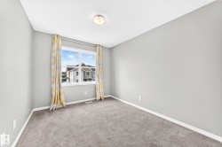 Carpeted flooring, neutral wall paint, white trim, and a window with white casing - 