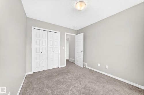 Neutral wall color, wall-to-wall carpeting, bi-fold closet doors, white trim, and ceiling-mounted light fixture - 20008 19 Avenue Nw, Edmonton, AB 