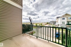 Balcony featuring a speckled concrete surface and black metal railings - 