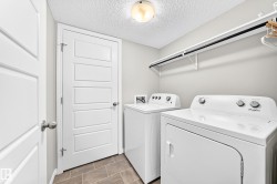 Tiled flooring, white paneled doors, wall-mounted shelving with hanging rod, and ceiling-mounted light fixture - 
