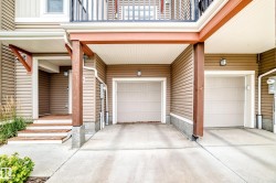Two attached garages with overhead doors, covered entryway, and exterior lighting - 