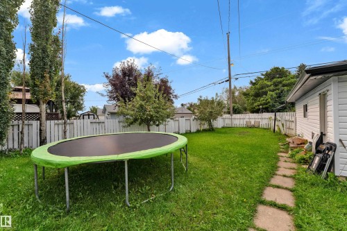 Expansive grassy yard with a white picket fence perimeter - 14216 58 Street Nw, Edmonton, AB 