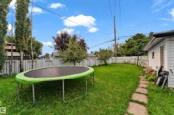 Expansive grassy yard with a white picket fence perimeter - 