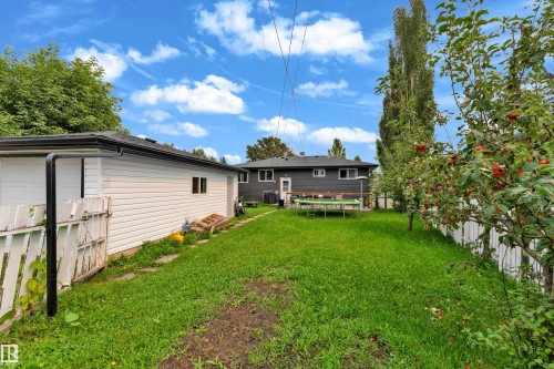 Expansive green lawn with mature trees and a white picket fence - 14216 58 Street Nw, Edmonton, AB 