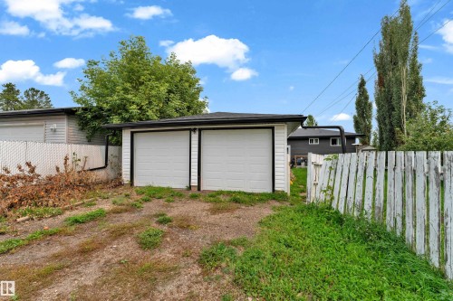 Two-car detached garage with white paneled doors and black trim - 14216 58 Street Nw, Edmonton, AB 