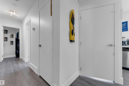 Hardwood-finish flooring with a modern flush-mount lighting fixture and white interior doors - 14216 58 Street Nw, Edmonton, AB 