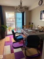 Dining area with wood-finish flooring, a contemporary chandelier, and a sliding glass door providing exterior access - 