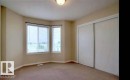 Recessed bay window with horizontal blinds, flush mount ceiling light fixture, and sliding closet doors - #9 2505 42 St Nw, Edmonton, AB 