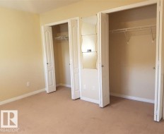 Carpeted flooring, bi-fold closet doors, wire shelving, and neutral wall tones - 