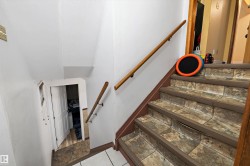 Staircase featuring wood-finish handrails and stone-look stair treads - 