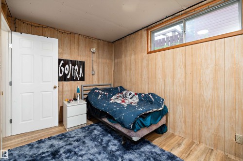 Wood-finish paneled walls with a contrasting white interior door - 10621 60A Avenue Nw, Edmonton, AB 