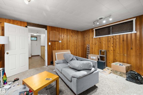 Interior space featuring wood paneling, white paneled door, and recessed window - 10621 60A Avenue Nw, Edmonton, AB 