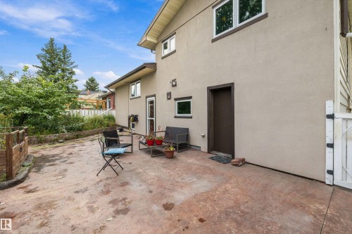 Stucco exterior with brown trim windows, multiple property access points, and a concrete patio - 10621 60A Avenue Nw, Edmonton, AB 