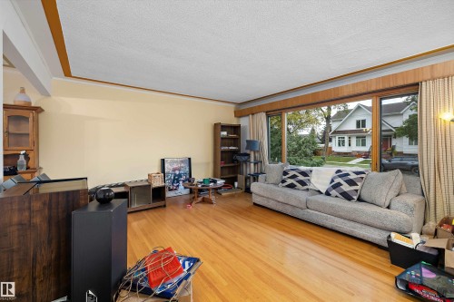 Hardwood flooring throughout, large windows with wood trim, and a built-in bookshelf - 10621 60A Avenue Nw, Edmonton, AB 
