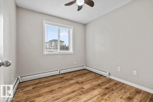 Wood-finish flooring, white window trim, and a ceiling fan - #110 4309 33 St, Stony Plain, AB 