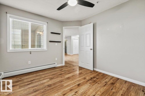 Wood-finish flooring, white walls, white trim, white window blinds, and a ceiling fan - #110 4309 33 St, Stony Plain, AB 