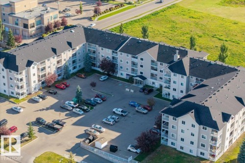 Multi-story residential building with private balconies and a paved parking area - #110 4309 33 St, Stony Plain, AB 
