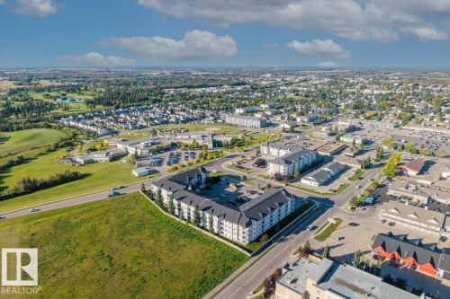 Expansive aerial perspective showcasing a residential and commercial area with abundant greenery - #110 4309 33 St, Stony Plain, AB 