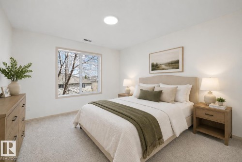 Light-colored carpeting and white walls complement the large window with white framing (virtually staged) - #353 2096 Blackmud Creek Dr Sw, Edmonton, AB - Indoor Photo Showing Bedroom