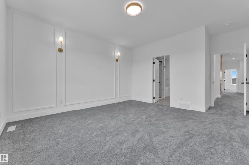 Plush carpeting, decorative wall molding, and contemporary wall sconces - 1129 Starling Drive Nw, Edmonton, AB 
