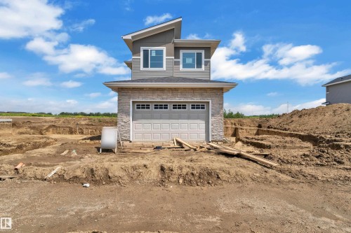 Modern architectural design with multi-pane windows and a gray garage door - 1129 Starling Drive Nw, Edmonton, AB 