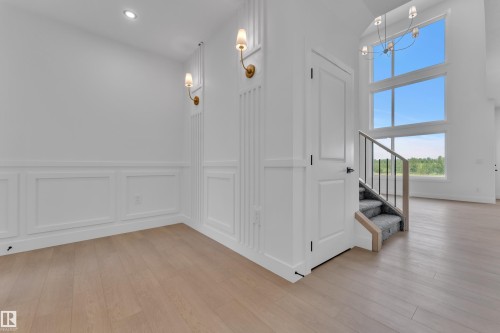 Wood-finish flooring throughout, wainscoting with decorative wall molding, recessed ceiling lighting, and a modern chandelier - 1129 Starling Drive Nw, Edmonton, AB 