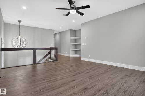 Wood-finish flooring, recessed lighting, ceiling fan, contemporary chandelier, and built-in shelving - 2219 22 Street Nw, Edmonton, AB 