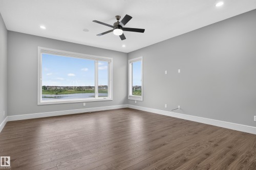 Expansive room with wood-finish flooring, recessed lighting, and a contemporary ceiling fan - 2219 22 Street Nw, Edmonton, AB 