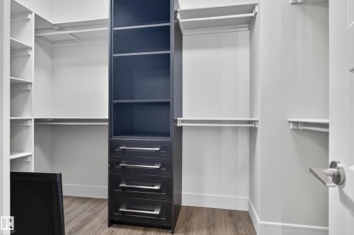 Built-in dark wood-finish shelving with integrated drawers, white shelving units, and wood-finish flooring - 2219 22 Street Nw, Edmonton, AB 