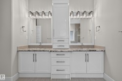 Dual vanity with white cabinetry, light-toned stone-finish countertop, and individual vessel sinks - 