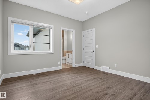 Wood-finish flooring, light gray wall color, white trim, and a white interior door - 2219 22 Street Nw, Edmonton, AB 