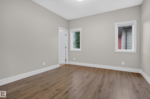 Neutral wall tones, wood-finish flooring, white trim, and two windows - 2219 22 Street Nw, Edmonton, AB 