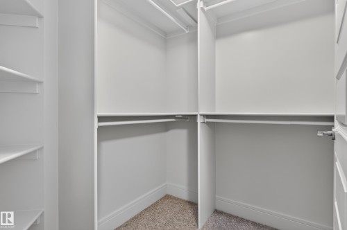 Custom closet system featuring multiple hanging rods and integrated shelving - 2219 22 Street Nw, Edmonton, AB 