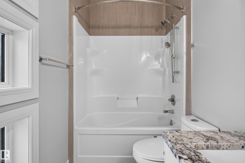 White shower/tub combination with a curved shower rod and a hand-held shower head - 2219 22 Street Nw, Edmonton, AB 