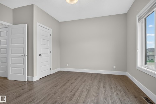 Wood-finish flooring, light grey wall paint, multiple panel doors, and a ceiling-mounted light fixture - 2219 22 Street Nw, Edmonton, AB 