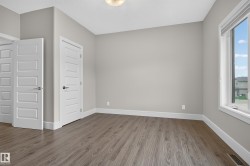 Wood-finish flooring, light grey wall paint, multiple panel doors, and a ceiling-mounted light fixture - 