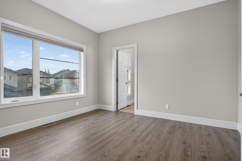 Expansive window, wood-finish flooring, light grey walls, white trim, and white interior door - 2219 22 Street Nw, Edmonton, AB 