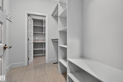 Customizable shelving system with ample storage, wood-finish tile flooring, and additional auxiliary storage space - 2219 22 Street Nw, Edmonton, AB 