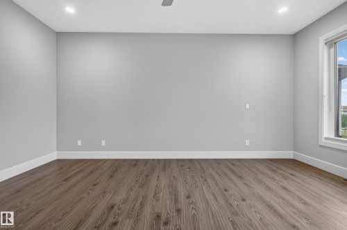 Recessed lighting, wood-finish flooring, and a large window with white trim - 2219 22 Street Nw, Edmonton, AB 