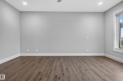 Recessed lighting, wood-finish flooring, and a large window with white trim - 