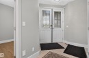 Double entry doors with decorative glass panels, modern overhead lighting, and light-toned tile flooring - 2219 22 Street Nw, Edmonton, AB 