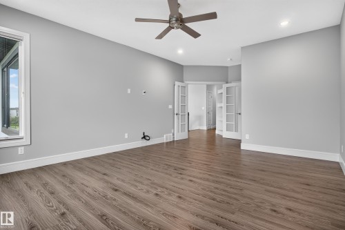 Wood-finish flooring throughout, complemented by a ceiling fan with integrated lighting - 2219 22 Street Nw, Edmonton, AB 