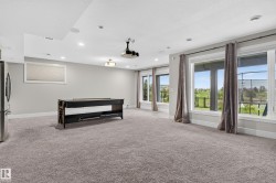 Spacious entertainment area with recessed lighting, large windows, wall-to-wall carpeting, and a ceiling-mounted projector - 
