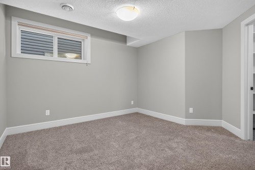 Neutral-toned walls, plush carpet flooring, a window with blinds, and recessed lighting - 2219 22 Street Nw, Edmonton, AB 