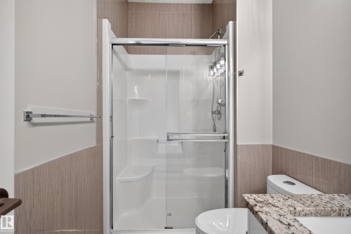 Enclosed shower with glass sliding door and integrated seating - 2219 22 Street Nw, Edmonton, AB 
