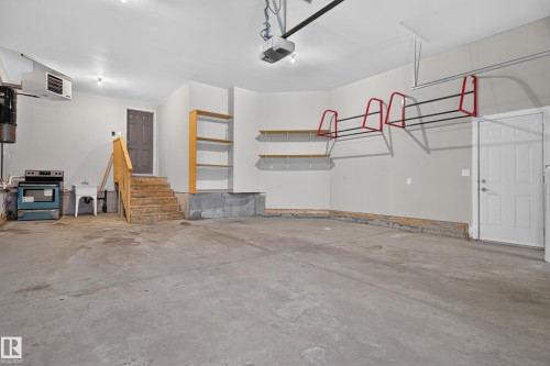 Concrete flooring, built-in shelving, overhead storage racks, elevated landing with stairs, and a utility sink - 2219 22 Street Nw, Edmonton, AB 