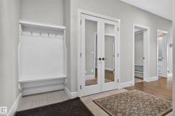 Built-in hall tree with bench, French doors with glass panels, wood-finish flooring, and light-toned wall paint - 