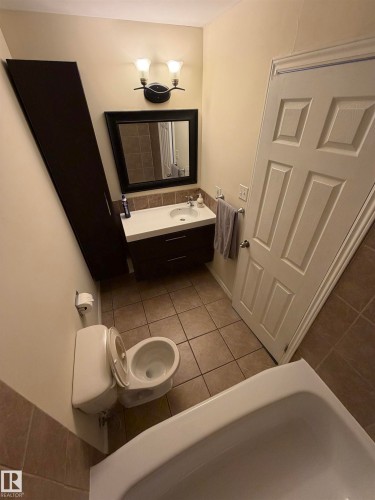 Bathroom featuring a floating vanity with an integrated sink, tile flooring, and a shower-tub combination - #209 11429 124 St Nw, Edmonton, AB 
