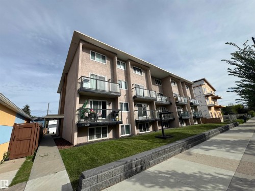 Stucco exterior with multiple private balconies featuring glass railings - #209 11429 124 St Nw, Edmonton, AB 
